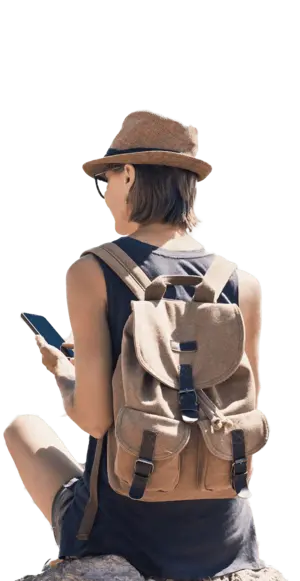 Femme person overlooking the acropolis, pictured from behind, holding mobile device.